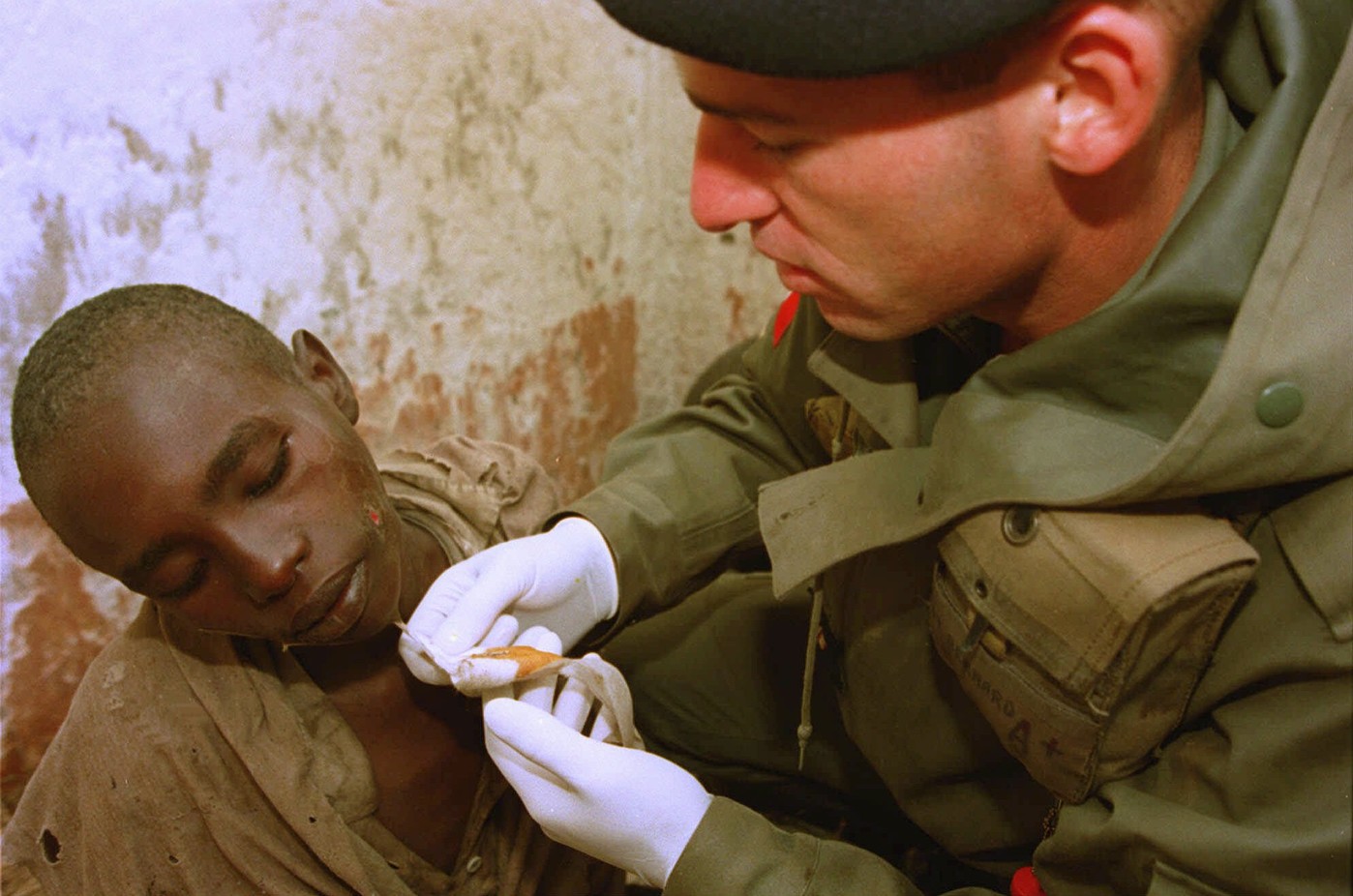 Un médecin de l’armée française s’occupe d'un garçon dans le camp de déplacés tutsis géré par l'armée française, Bisesero le 2 juillet 1994. Jean-Marc Bouju/AP